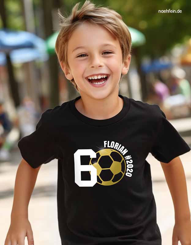Kleiner Junge feiert seinen 6. Kindergeburtstag in einem personalisierten Fußball-Shirt mit goldenem Ball und eigenem Namen
- naehfein 